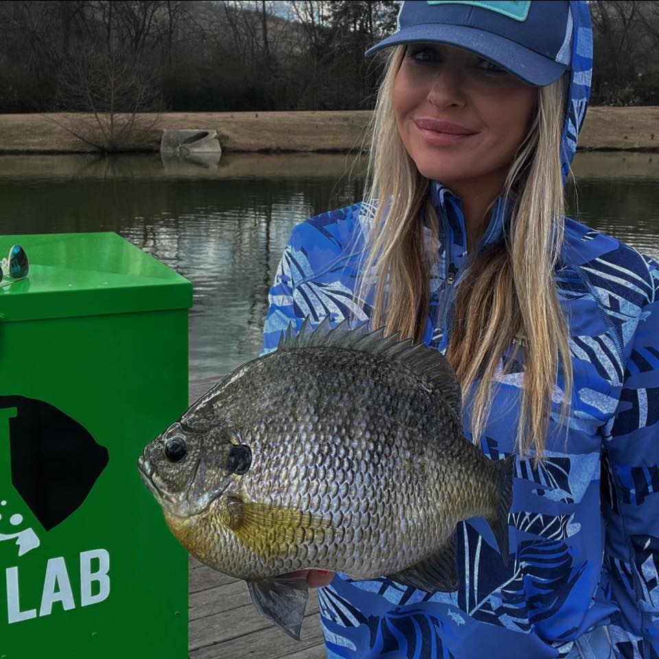 Sarah Parvin holding a trophy coppernose bluegill on the dock at the Slab Lab